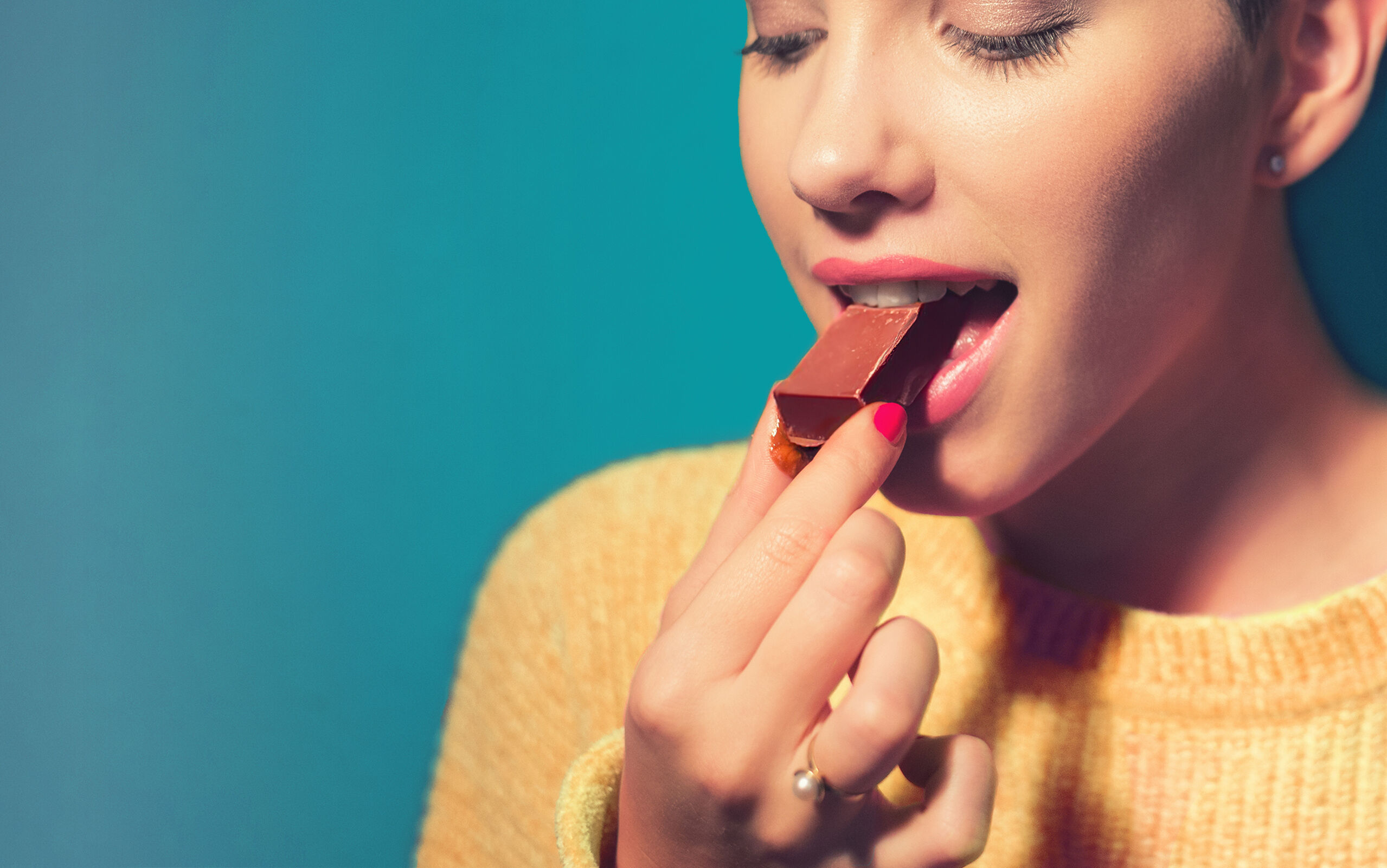 Frau isst genüsslich kakaofreie Schokolade