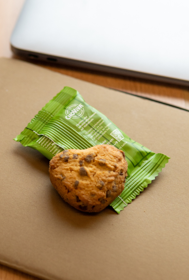 Cookie with packaging, placed on a notebook next to a laptop.